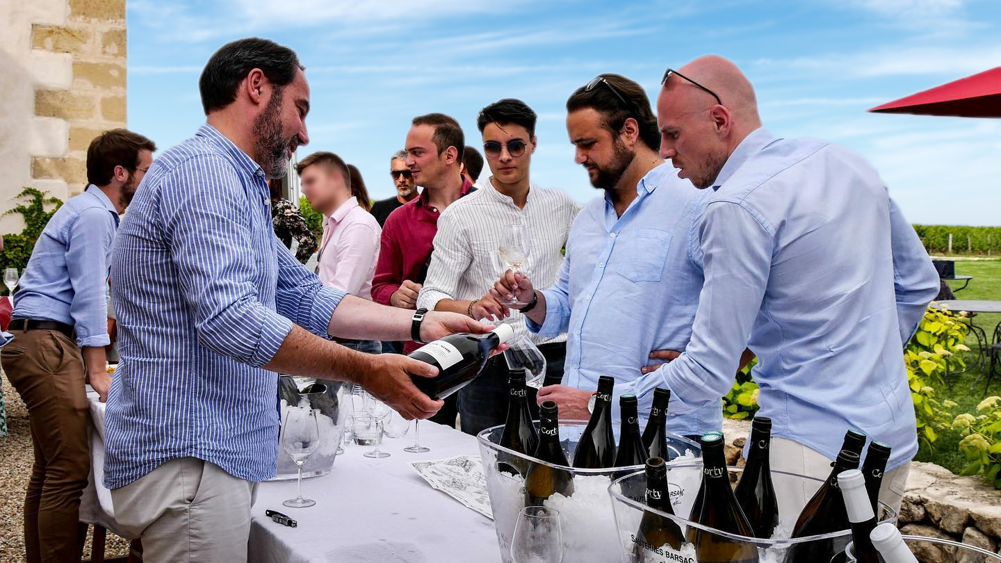 Image of smiling restaurateurs sharing bottles of wine